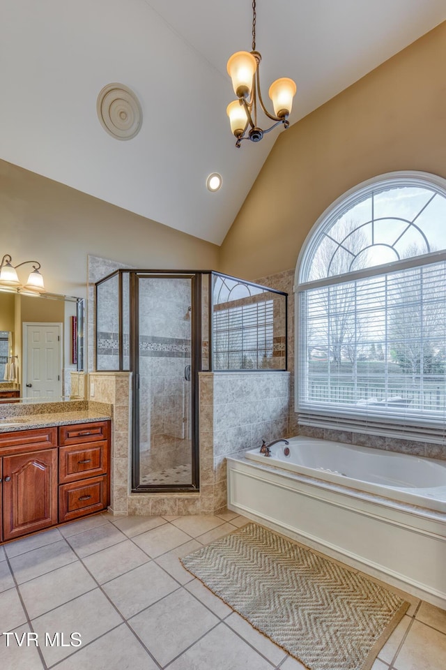 bathroom with a garden tub, a notable chandelier, lofted ceiling, vanity, and tile patterned flooring