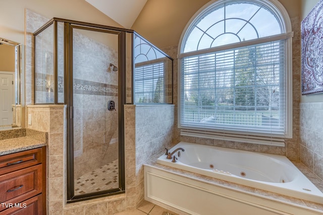 full bathroom with lofted ceiling, a healthy amount of sunlight, a shower stall, and a whirlpool tub