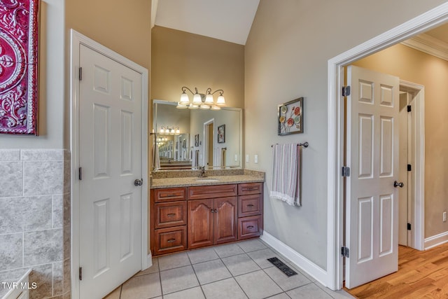 bathroom featuring tile walls, visible vents, vaulted ceiling, vanity, and tile patterned flooring