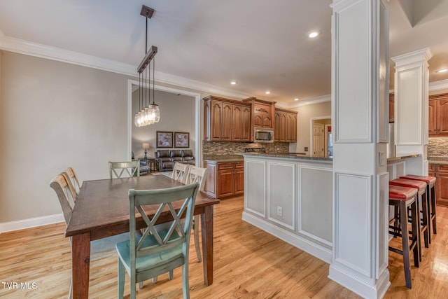 dining space with recessed lighting, an inviting chandelier, ornamental molding, light wood-type flooring, and baseboards