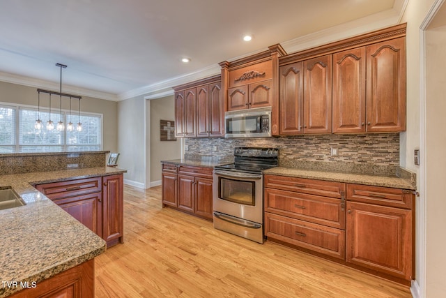 kitchen featuring decorative light fixtures, stainless steel appliances, brown cabinetry, ornamental molding, and light wood-type flooring