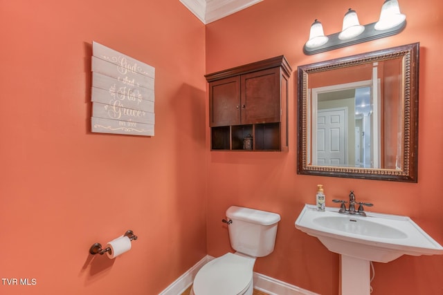 bathroom featuring ornamental molding, baseboards, a sink, and toilet