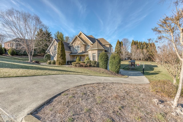 view of front of house with stone siding and a front lawn