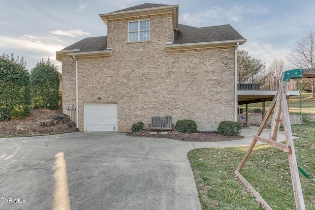 view of home's exterior featuring a playground, a garage, brick siding, driveway, and roof with shingles