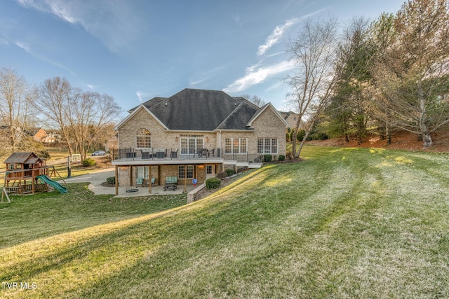 rear view of house featuring a patio area, a yard, and a playground