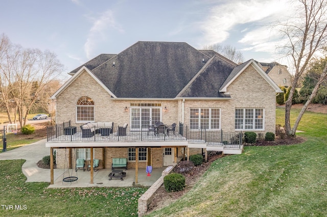 back of property featuring brick siding, a yard, and a patio