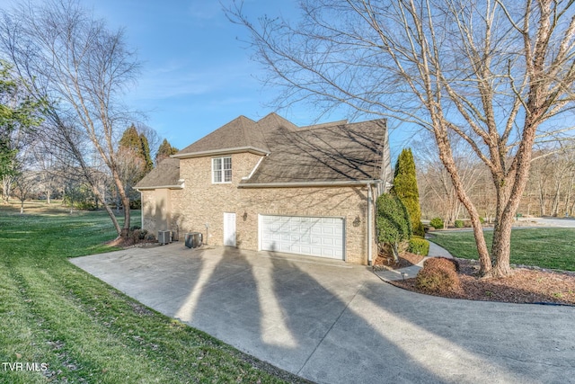 view of home's exterior with central AC unit, brick siding, a yard, concrete driveway, and roof with shingles