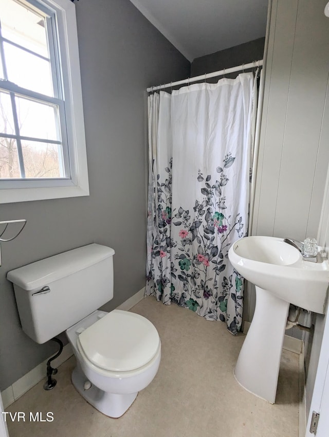 bathroom with a shower with shower curtain and toilet