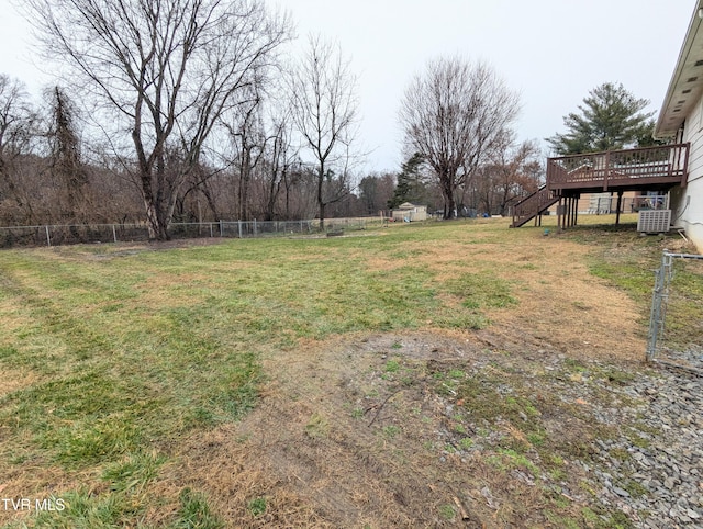 view of yard with central air condition unit, a wooden deck, and a storage shed