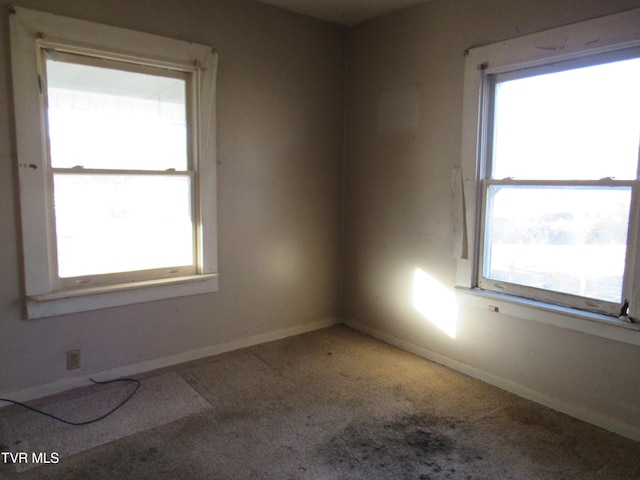 spare room with carpet and baseboards