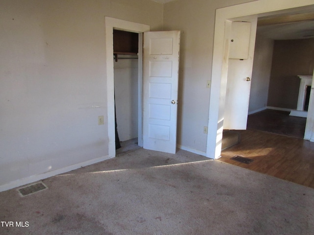 unfurnished bedroom with visible vents, baseboards, carpet floors, a fireplace, and a closet