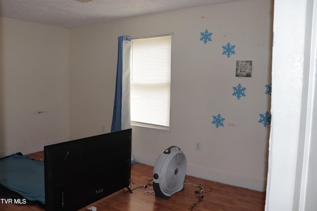 bedroom with hardwood / wood-style floors and a textured ceiling