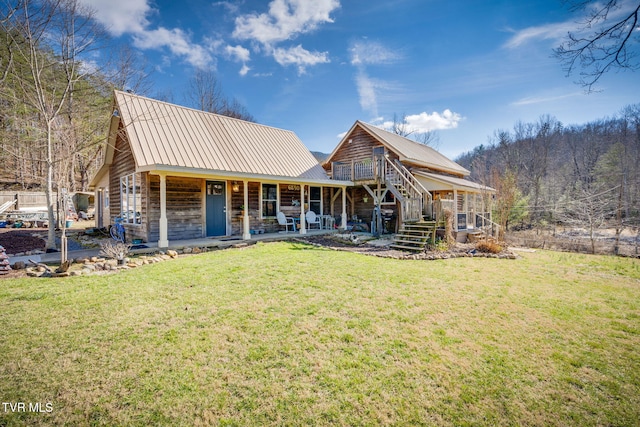 rear view of property with a yard and covered porch