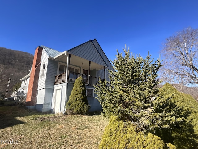 view of side of home with metal roof and a chimney