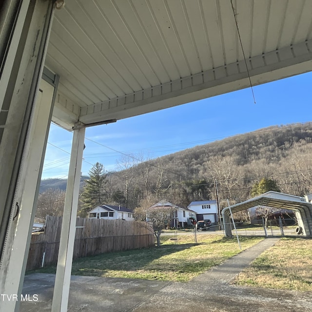 view of yard with a carport and fence