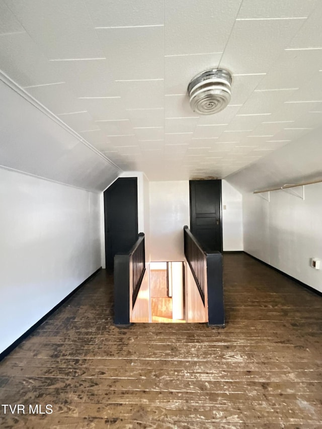 additional living space with vaulted ceiling, baseboards, and wood finished floors