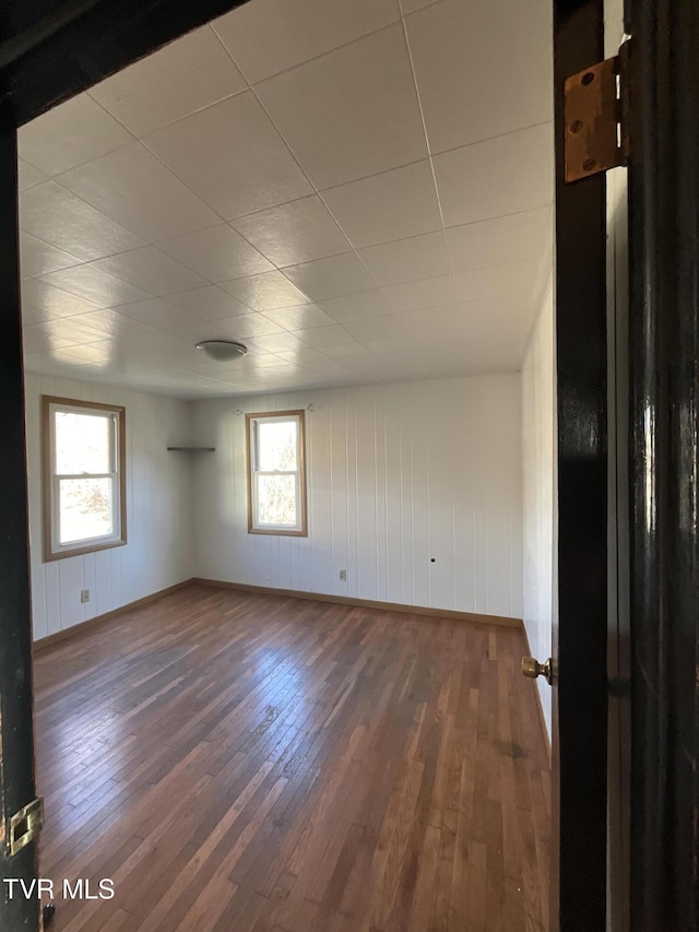 spare room featuring hardwood / wood-style flooring and baseboards