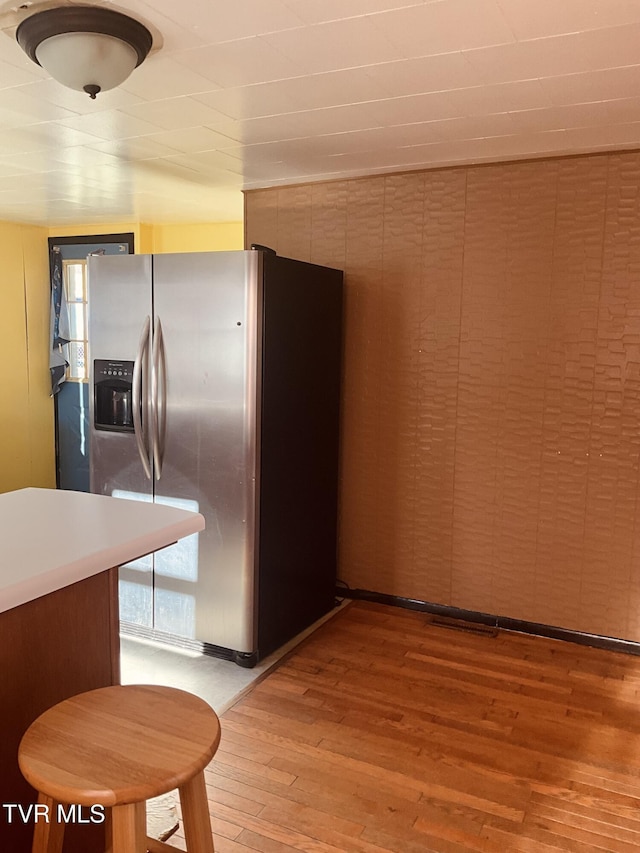 kitchen featuring light countertops, light wood-type flooring, and stainless steel fridge