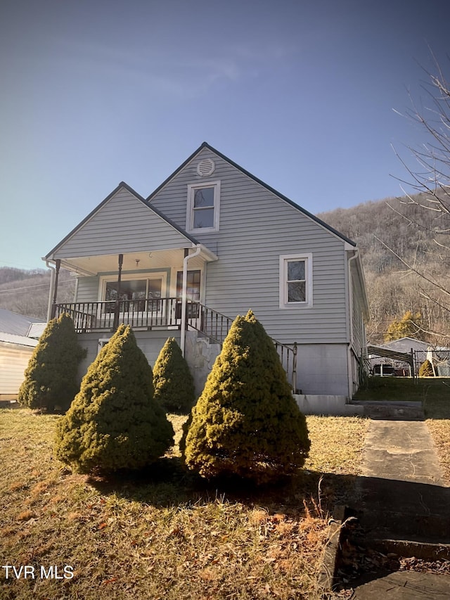 rear view of property featuring covered porch