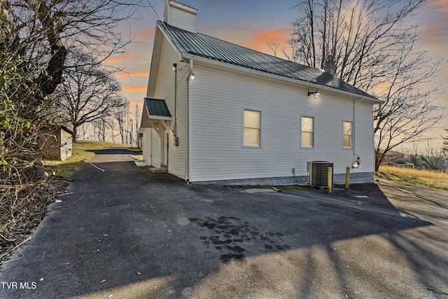 property exterior at dusk featuring central air condition unit