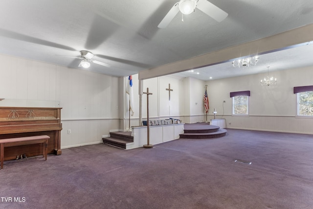 unfurnished room featuring ceiling fan with notable chandelier and carpet