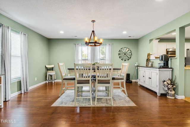 dining area featuring dark hardwood / wood-style flooring, an inviting chandelier, and a textured ceiling
