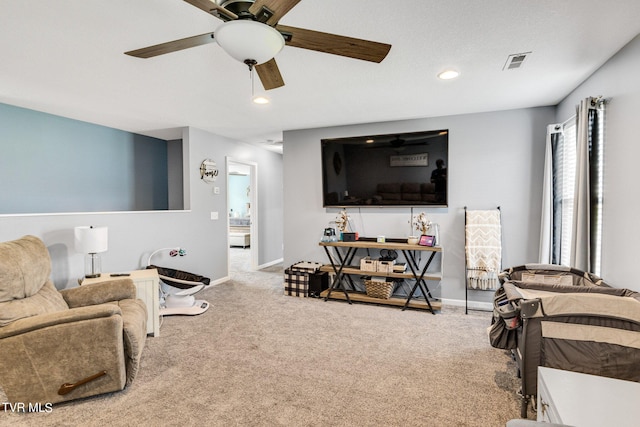 carpeted living room with ceiling fan