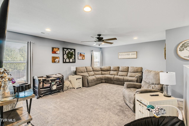 living room featuring ceiling fan and light colored carpet