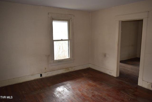 unfurnished room with dark hardwood / wood-style flooring