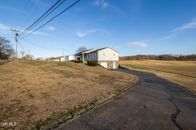 view of front facade with a garage, driveway, and a front lawn