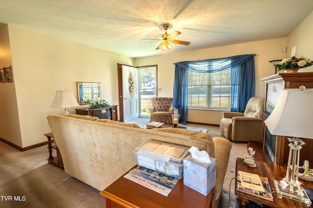 living area with a ceiling fan, carpet, baseboards, and a textured ceiling