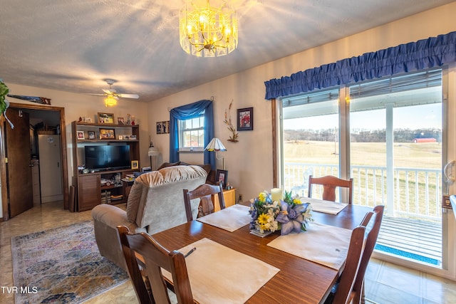 dining area with ceiling fan with notable chandelier