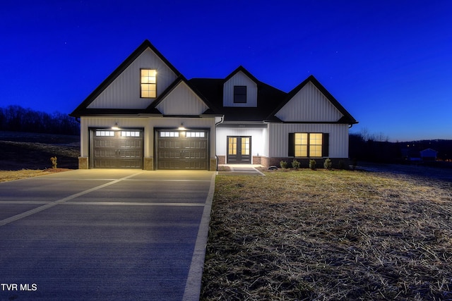 modern farmhouse style home featuring concrete driveway, brick siding, and french doors