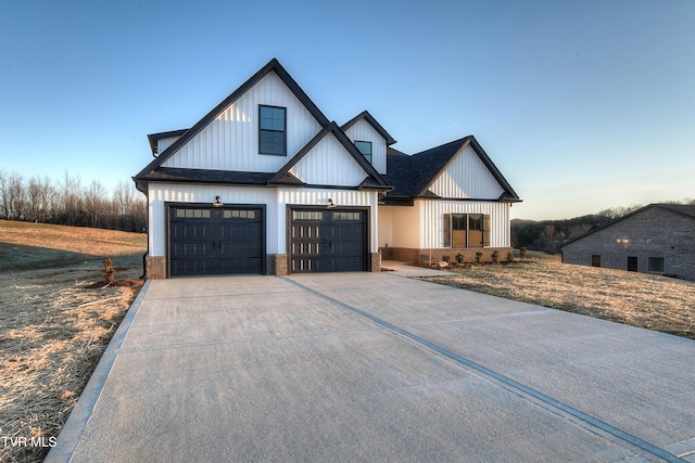 modern inspired farmhouse with a garage, brick siding, driveway, and board and batten siding