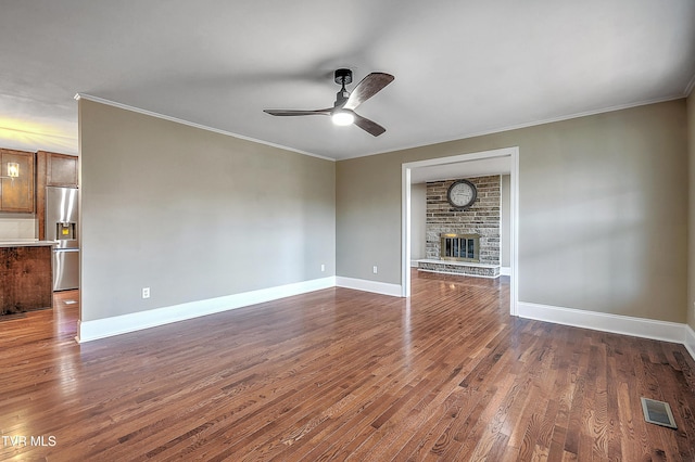 unfurnished living room featuring ornamental molding, ceiling fan, dark wood-type flooring, and a fireplace