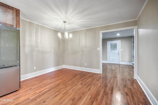 unfurnished dining area featuring baseboards, crown molding, a notable chandelier, and hardwood / wood-style floors