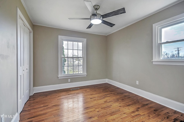 unfurnished bedroom featuring a closet, visible vents, baseboards, and hardwood / wood-style flooring