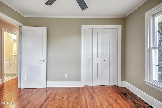 unfurnished bedroom featuring multiple windows, baseboards, and wood finished floors