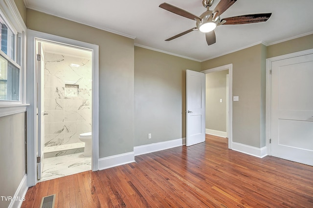 unfurnished bedroom featuring baseboards, visible vents, wood finished floors, and ornamental molding