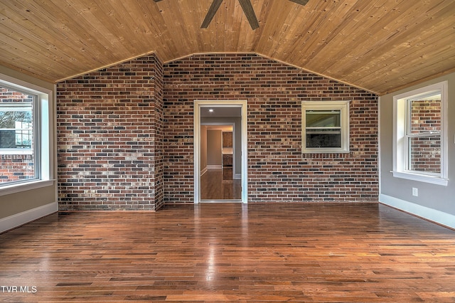 empty room with wood ceiling, brick wall, and wood finished floors