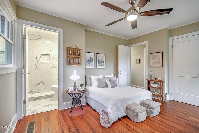 bedroom featuring ornamental molding, wood finished floors, visible vents, and baseboards