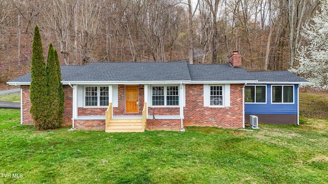 ranch-style home with a chimney, a front yard, brick siding, and roof with shingles