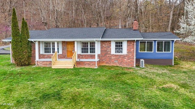 single story home featuring a chimney, a shingled roof, a front lawn, and brick siding