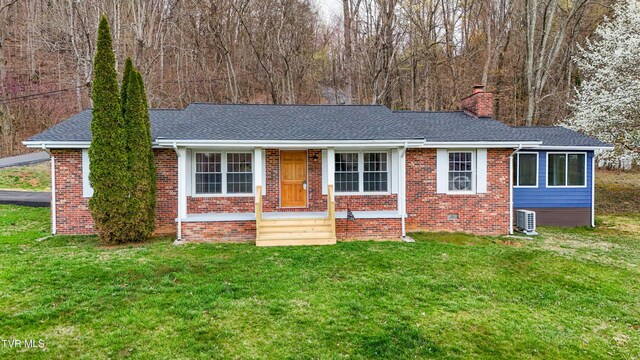 ranch-style house featuring central air condition unit, a chimney, a front yard, brick siding, and roof with shingles