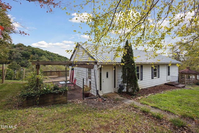 view of side of home with a yard and a gazebo