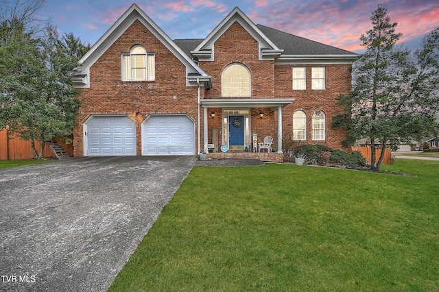 front of property with a garage and a lawn