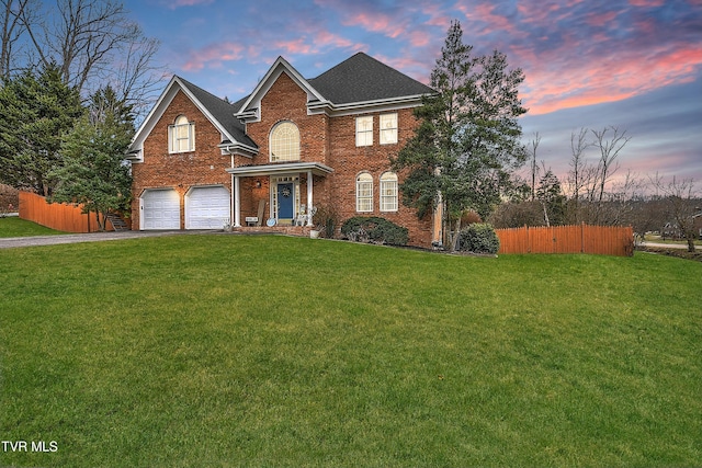 front facade featuring a garage and a lawn