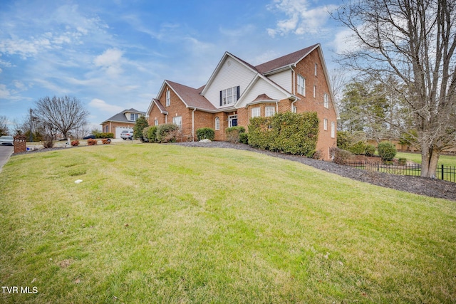 traditional home with brick siding, fence, and a front lawn