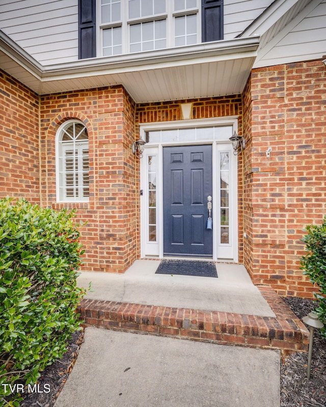 view of exterior entry with brick siding