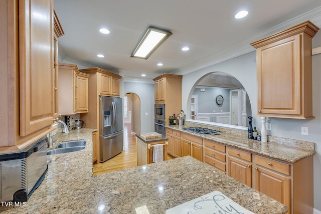 kitchen featuring arched walkways, light stone counters, ornamental molding, stainless steel appliances, and a sink